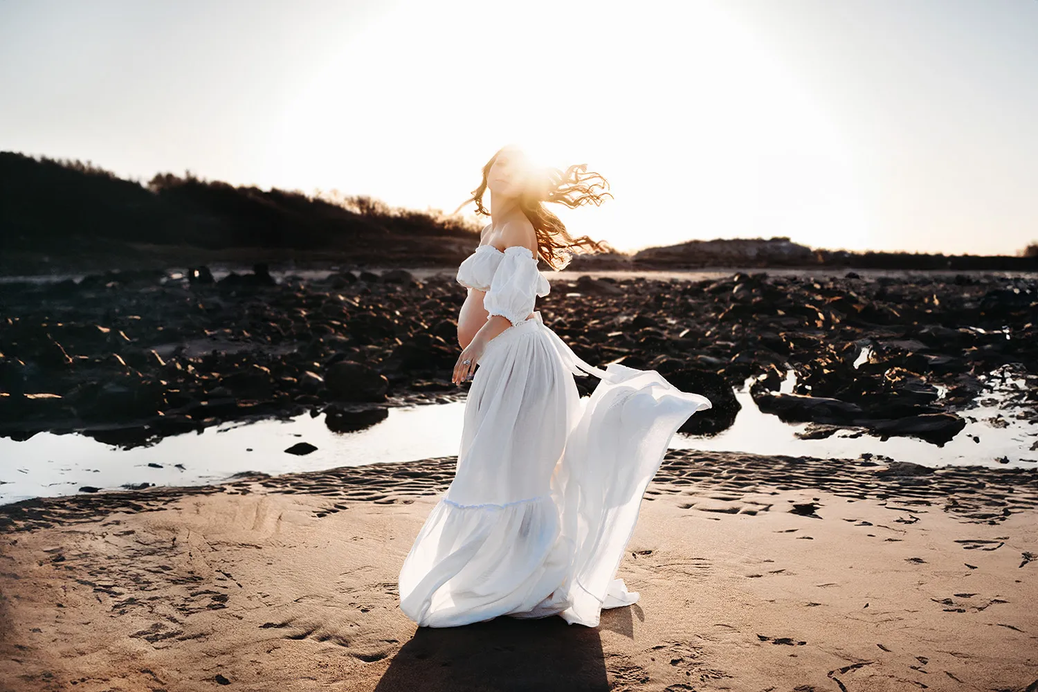 Boston Maternity Photographer Caryn Scanlan took this photograph of a pregnant mama at a beach in Gloucester, MA in early spring